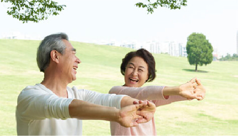 高齢の夫婦が笑顔で体操をしている画像
