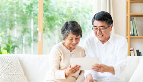 高齢の夫婦がタブレット端末で認知機能を確認している画像